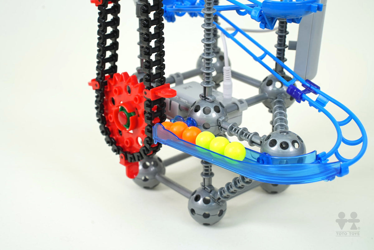 Close-up of the LoopTech chain lift, red sprockets and blue rails carrying orange and yellow balls