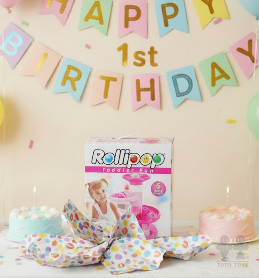 First birthday party scene with the pink Rollipop Toddler Fun box, two cakes and confetti banner